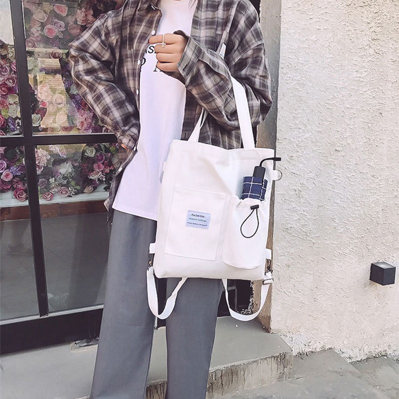 Harajuku canvas backpack with three straps, pockets, and letter details in four colors.