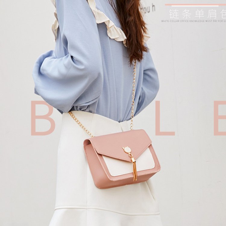 Small square messenger bag with cat tassel decoration and chain strap.